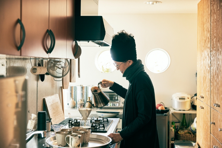 丸窓から優しい光がこぼれるキッチンで取材スタッフのためにコーヒーを淹れる南さん