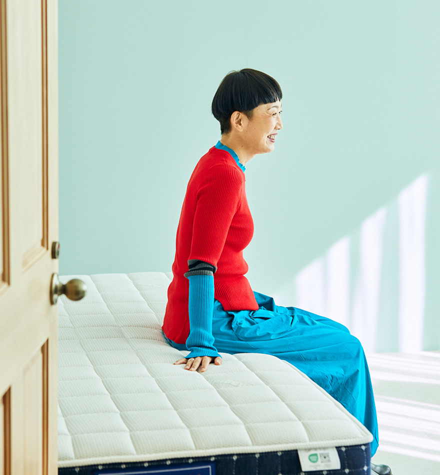 マットレスに腰かけている本多 り子さん